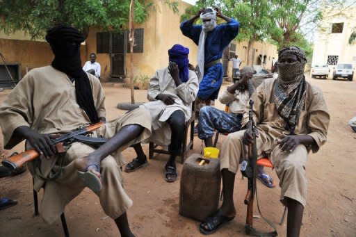 Movement for Oneness and Jihad in West Africa (MUJAO) Islamist fighters sit in the courtyard of the Islamist police station in Gao in July 2012. Dozen of Algerian jihadists have arrived in the Malian city of Timbuktu to support armed Islamist groups who are imposing an increasingly brutal version of sharia law in the vast northern areas under their control, security sources said Sunday