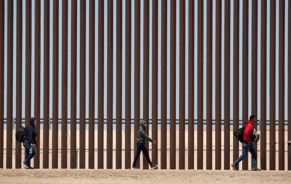 Migrants recently wait to be processed at Gate 40 of the border wall after having crossed the Rio Grande from Juárez in their bid for asylum.