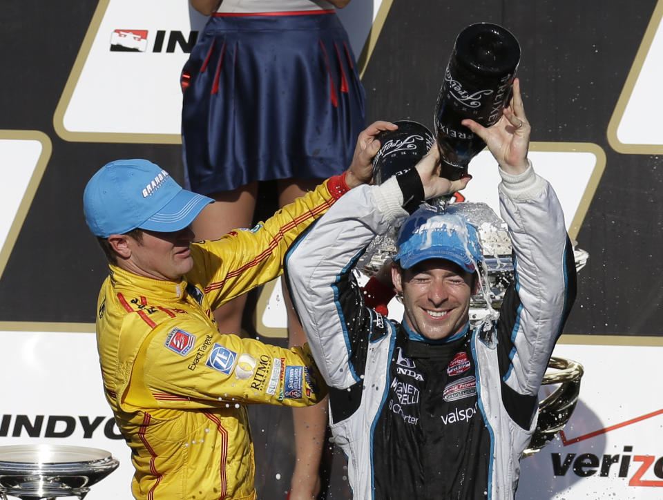 Simon Pagenaud, right, of France, pours sparkling wine over his head as he celebrates winning the inaugural Grand Prix of Indianapolis IndyCar auto race with second-place finisher Ryan Hunter-Reay at the Indianapolis Motor Speedway in Indianapolis, Saturday, May 10, 2014. (AP Photo/Darron Cummings)