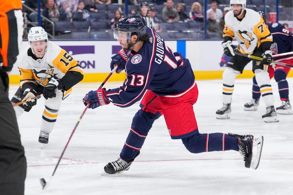 Sep 25, 2022; Columbus, Ohio, USA;  Columbus Blue Jackets left wing Johnny Gaudreau (13) fires a shot past Pittsburgh Penguins right wing Josh Archibald (15) during the preseason NHL hockey game at Nationwide Arena. Mandatory Credit: Adam Cairns-The Columbus Dispatch