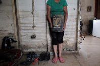 <p>Aurea Esther Gonzalez holds a bible dirty with mud, after Hurricane Maria hit the island in September, in Toa Baja, Puerto Rico, Oct. 18, 2017. (Photo: Alvin Baez/Reuters) </p>