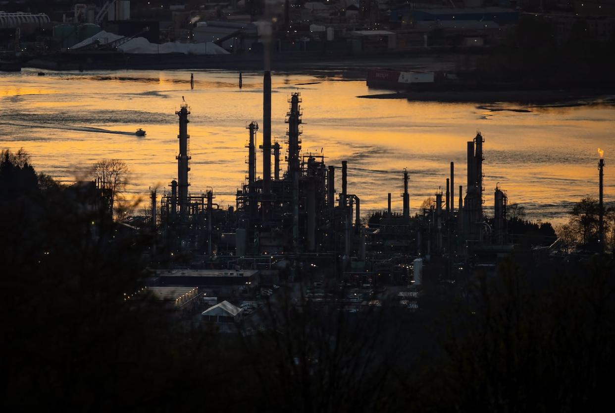The Parkland refinery is silhouetted against the Burrard Inlet at sunset in Burnaby, B.C., in April 2021. (Darryl Dyck/The Canadian Press - image credit)