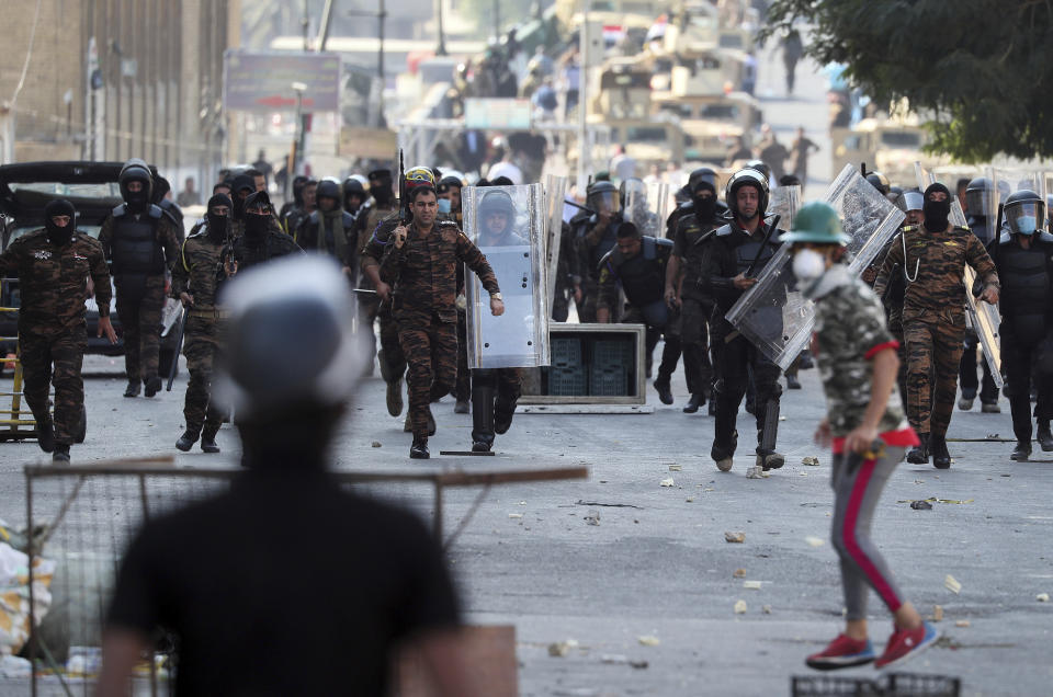Iraqi anti-riot police try to prevent anti-government protesters from crossing the al- Shuhada (Martyrs) bridge in central Baghdad, Iraq, Wednesday, Nov. 6, 2019. Tens of thousands of people have taken to the streets in recent weeks in the capital, Baghdad, and across the Shiite south, demanding sweeping political change. (AP Photo/Hadi Mizban)