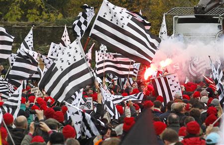 Protesters wearing red caps, the symbol of protest in Brittany and waving Breton regional flags, take part in a demonstration to maintain jobs in the region and against an "ecotax" on commercial trucks, in Carhaix, western France, November 30, 2013. REUTERS/Mal Langsdon