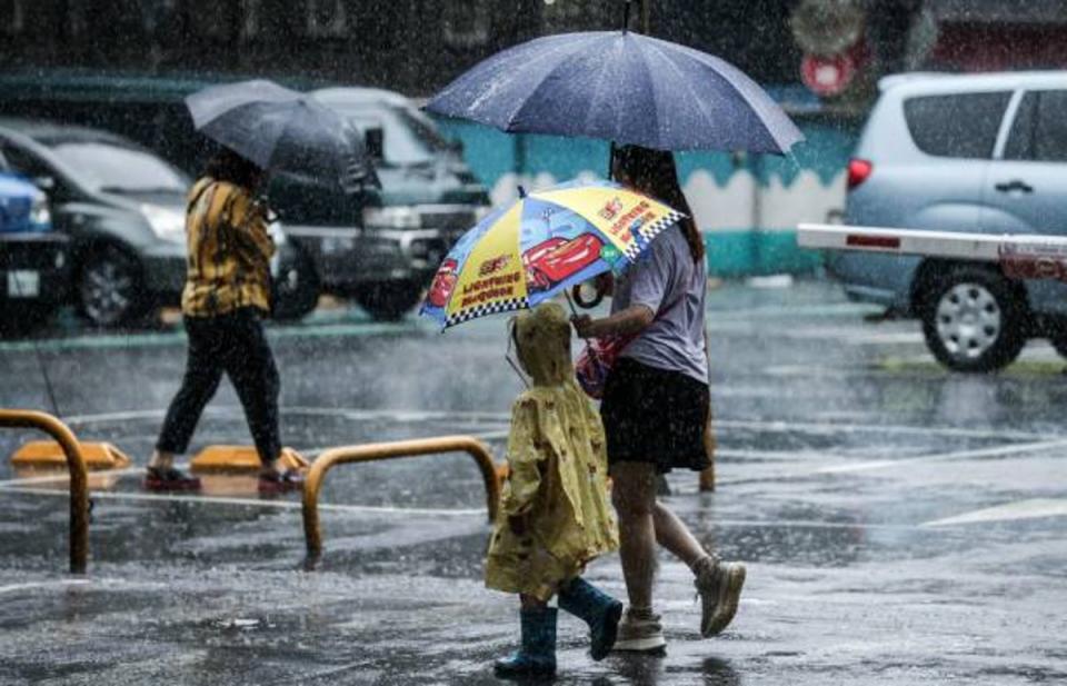 People hold umbrellas while walking on the street in the rain in Keelung after Typhoon Haikui hits Taiwan on 4 September 2023 (AFP via Getty Images)