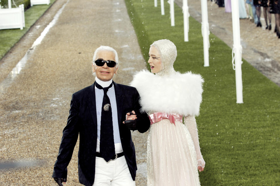 Lagerfeld walks the runway with a model during the Chanel fall/winter 2007 couture show in Paris on July 3, 2007.&nbsp;