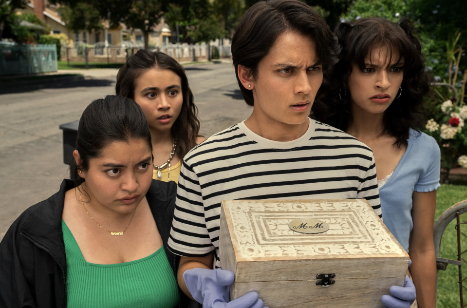 teens looking shocked and disgusted as one in their group holds a wooden box with gloves