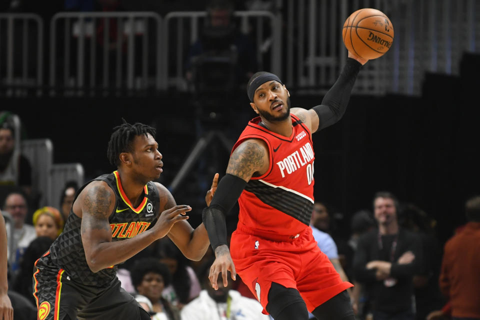 Portland Trail Blazers forward Carmelo Anthony, right, keeps the ball high away from Atlanta Hawks guard Treveon Graham, left, during the first half of an NBA basketball game Saturday, Feb. 29, 2020, in Atlanta. (AP Photo/John Amis)