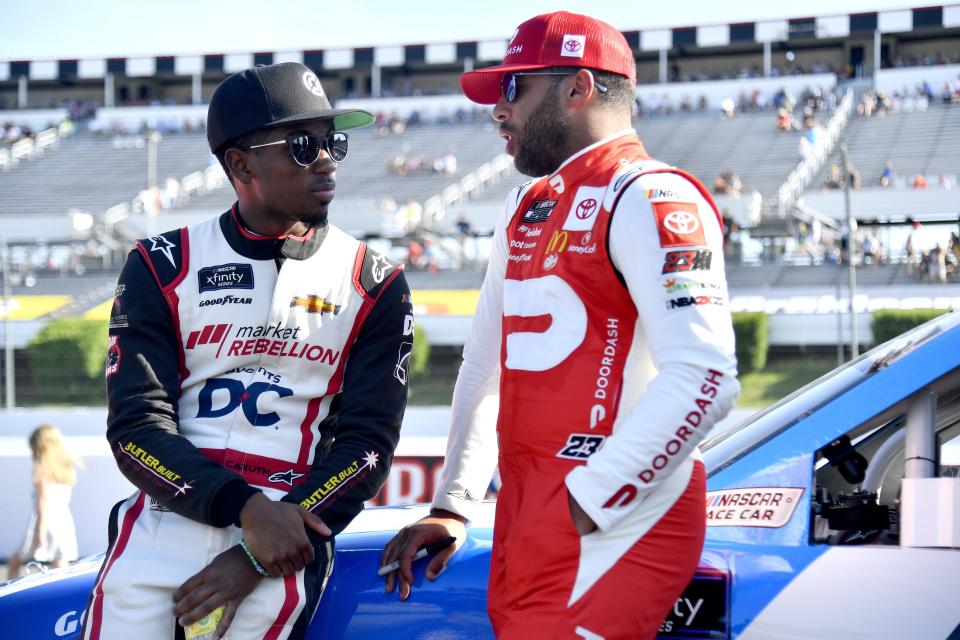 LONG POND, PENNSYLVANIA - JULY 23: Rajah Caruth, driver of the #44 Martin De Porres Chevrolet, (L) speaks with Bubba Wallace, driver of the #23 DoorDash Toyota, on the grid prior to the NASCAR Xfinity Series Explore the Pocono Mountains 225 at Pocono Raceway on July 23, 2022 in Long Pond, Pennsylvania. (Photo by Logan Riely/Getty Images) | Getty Images