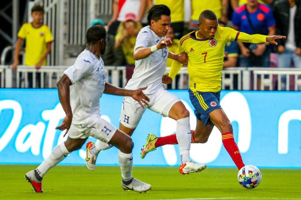 El jugador de Colombia Iván López (7) conduce el balón ante la marca de Denil Maldonado, de Honduras, en el partido amistoso celebrado el 16 de enero de 2022 en el DRV PNK Stadium en Fort Lauderdale, Florida.