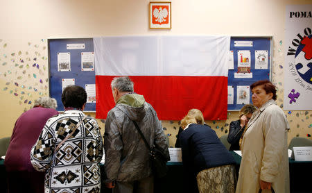 People line up to receive their voting ballots during the Polish regional elections, at a polling station in Warsaw, Poland, October 21, 2018. REUTERS/Kacper Pempel
