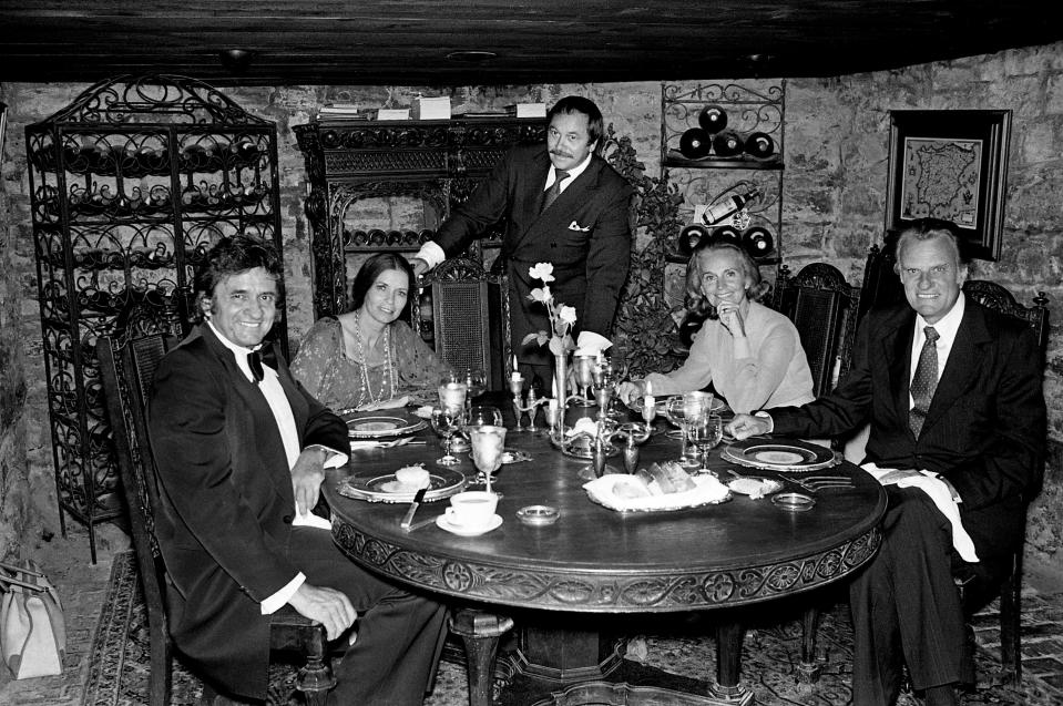 Johnny and June Carter Cash, left, and the Rev. and Mrs. Billy Graham enjoy supper at Mario's restaurant June 25, 1979, after the crusade. With them is their host Mario Ferrari, center.