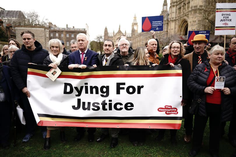 Infected blood victims and campaigners protest on College Green in Westminster, London