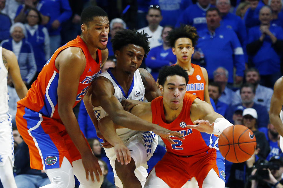 Kentucky's Ashton Hagans, middle, is sandwiched between Florida's Andrew Nembhard (2) and Kerry Blackshear Jr., left, in the second half of an NCAA college basketball game in Lexington, Ky., Saturday, Feb. 22, 2020. Kentucky won 65-59. (AP Photo/James Crisp)