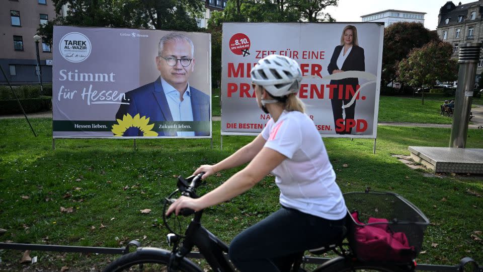 A woman rides a bicycle past election posters in Frankfurt. - Kirill Kudryavtsev/AFP/Getty Images