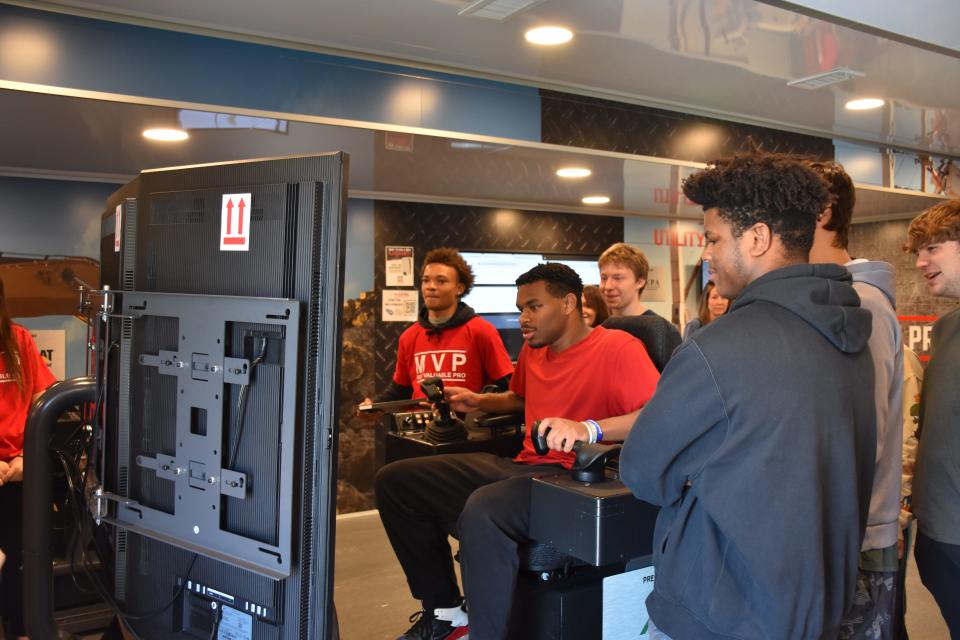 A Gallatin High School student draws a crowd as he drives an excavator simulator aboard the mobile workshop.