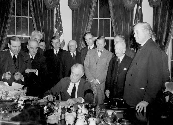 U.S. President Franklin D. Roosevelt signs the declaration of war following the Japanese bombing of Pearl Harbor