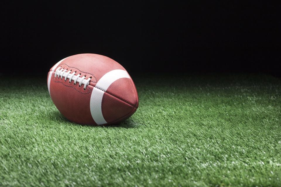 Football on grass against dark background