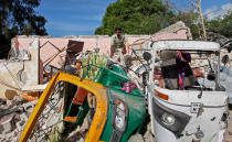 <p>A member of Somalia’s security forces walks past destroyed vehicles at the scene of a car bomb blast and gun battle targeting a restaurant in Mogadishu, Somalia Thursday, June 15, 2017. (Photo: Farah Abdi Warsameh/AP) </p>