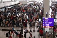 Passengers queue as the airport reopened a day after flights were halted due to a protest, at Hong Kong International Airport, China