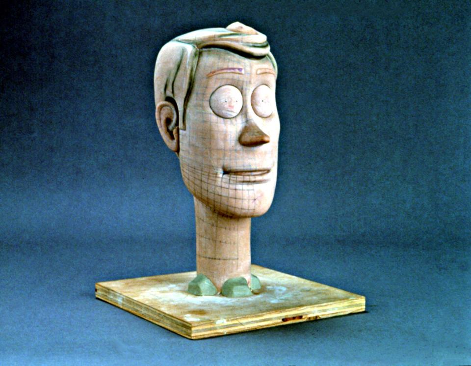 Wooden prototype head of Woody from Toy Story on a wooden base