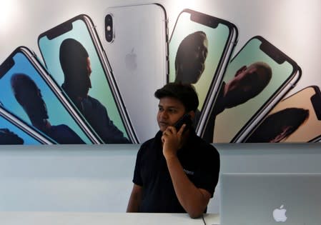 FILE PHOTO: Salesperson speaks on the phone at an Apple reseller store in Mumbai