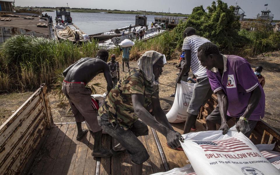 Workers crossload WFP bags of yellow split peas at a port in Malakal, Upper Nile State - WFP/Gabriela Vivacqua 