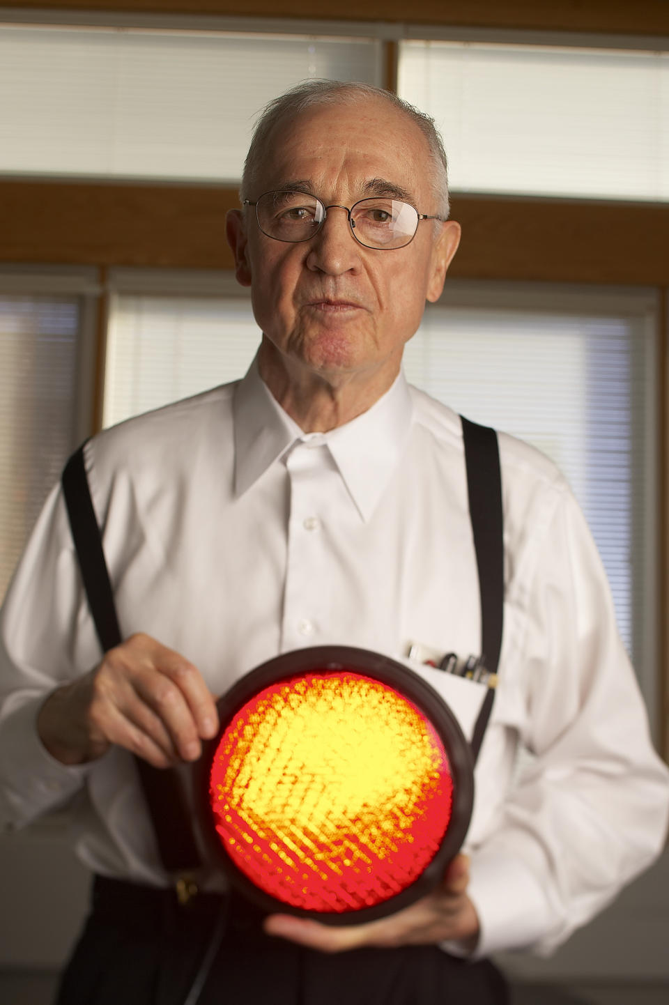 University of Illinois Professor Nick Holonyak, Jr., inventor of the light-emitting diode, holds a part of a stoplight that utilizes brighter, current version LED's designed by students of his. (Photo by Ralf-Finn Hestoft/Corbis via Getty Images)