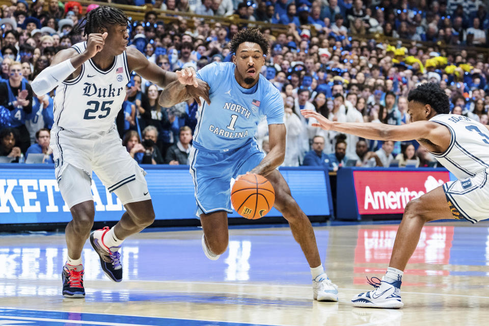 North Carolina forward Leaky Black (1) drives to the basket while guarded by Duke forward Mark Mitchell (25) and guard Jeremy Roach, right, in the first half of an NCAA college basketball game on Saturday, Feb. 4, 2023, in Durham, N.C. (AP Photo/Jacob Kupferman)