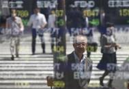 People are reflected on a stock quotation board outside a brokerage in Tokyo May 7, 2014. REUTERS/Toru Hanai