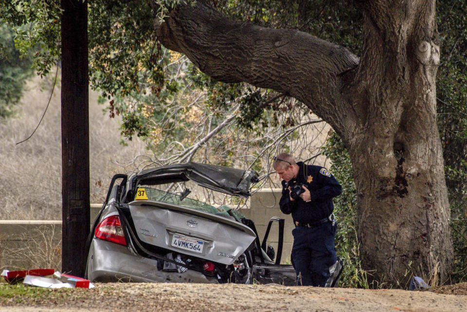 An officer with the California Highway Patrol's (CHP) Multidisciplinary Accident Investigation Team (MAIT) investigates the scene of a deadly crash in the Temescal Valley, south of Corona, Calif., Monday, Jan. 20, 2020. A Southern California driver intentionally rammed a Toyota Prius with several teenage boys inside, killing a few and injuring a few others before fleeing, authorities said Monday. (Watchara Phomicinda/The Orange County Register via AP)