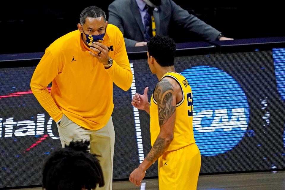 Michigan coach Juwan Howard speaks with guard Eli Brooks during the second half of the Elite Eight game in the NCAA tournament on Tuesday, March 30, 2021, in Indianapolis.