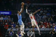 Los Angeles Clippers forward Paul George, left, shoots against Detroit Pistons forward Jerami Grant during the first half of an NBA basketball game, Friday, Nov. 26, 2021, in Los Angeles. (AP Photo/Ringo H.W. Chiu)