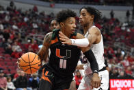 Miami guard Jordan Miller (11) tries to get past Louisville forward JJ Traynor (12) during the first half of an NCAA college basketball game in Louisville, Ky., Sunday, Dec. 4, 2022. (AP Photo/Timothy D. Easley)