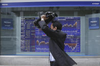 A man walks by an electronic stock board of a securities firm in Tokyo, Wednesday, Nov. 27, 2019. Shares were mostly higher in Asia on Wednesday after a fresh set of record highs on Wall Street, spurred by encouraging signs on trade talks between the U.S. and China. (AP Photo/Koji Sasahara)