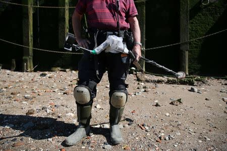 Mudlark Malcolm "Mack" Macduff looks for objects on the banks of the River Thames in London, Britain May 24, 2016. REUTERS/Neil Hall