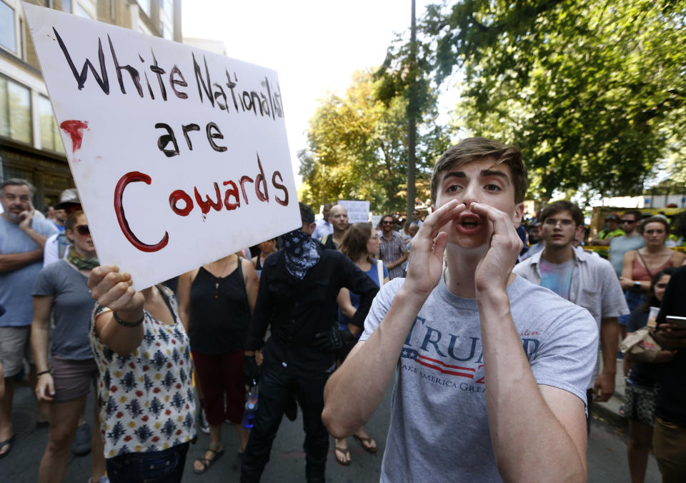 <p>A counterprotester, left, holds a sign beside a man wearing a T-shirt bearing President Donald Trump’s name at a “Free Speech” rally by conservative activists on Boston Common, Saturday, Aug. 19, 2017, in Boston, Mass. (Photo: Michael Dwyer/AP) </p>