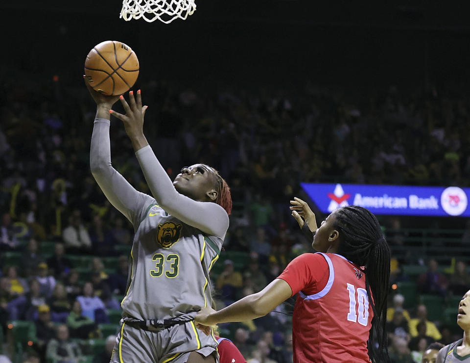 Baylor guard Aijha Blackwell (33) scores past Delaware State forward Arianna Johnson (10) during the second half of an NCAA college basketball game Thursday, Dec. 14, 2023, in Waco, Texas. (Jerry Larson/Waco Tribune-Herald via AP)