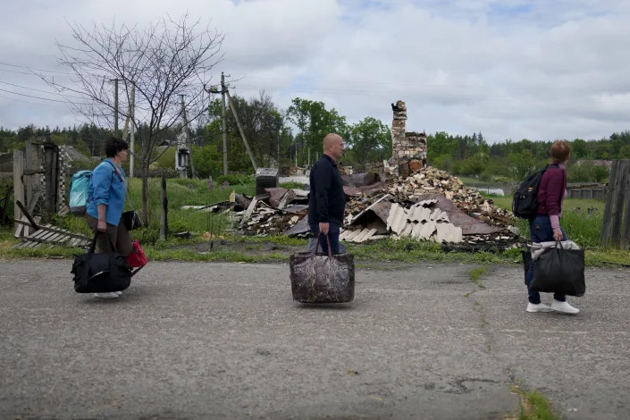 From right, Nila Zelinska, Eduard Zelenskyy, and Natalia Didenko arrive to their home town after escaping war in Potashnya, on the outskirts of Kyiv, Ukraine, Tuesday, May 31, 2022. (AP Photo/Natacha Pisarenko)