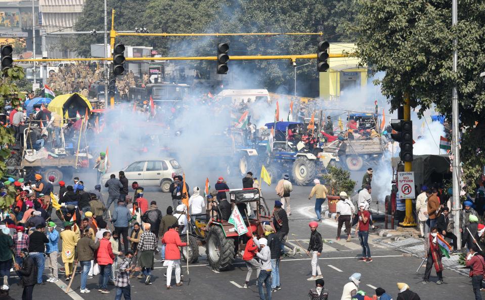 NEW DELHI, INDIA - JANUARY 26: Tear gas fired by police to stop protesting farmers on tractors after they entered the city on Republic Day at ITO on January 26, 2021 in New Delhi, India. Major scenes of chaos and mayhem at Delhi borders as groups of farmers allegedly broke barricades and police check posts and entered the national capital before permitted timings. Police used tear gas at Delhi's Mukarba Chowk to bring the groups under control. Clashes were also reported at ITO, Akshardham. Several rounds of talks between the government and protesting farmers have failed to resolve the impasse over the three farm laws. The kisan bodies, which have been protesting in the national capital for almost two months, demanding the repeal of three contentious farm laws have remained firm on their decision to hold a tractor rally on the occasion of Republic Day.(Photo by Arvind Yadav/Hindustan Times via Getty Images)