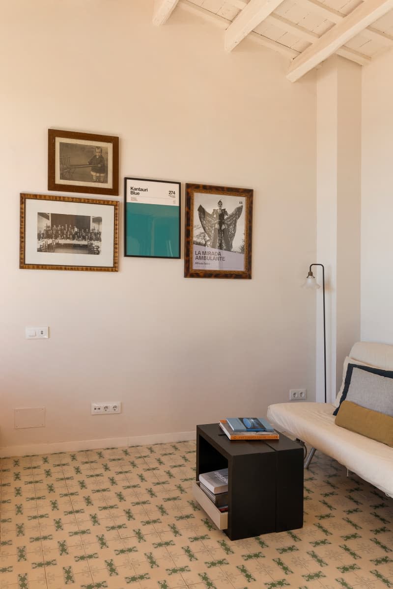 white living room with some framed art and futon sofa