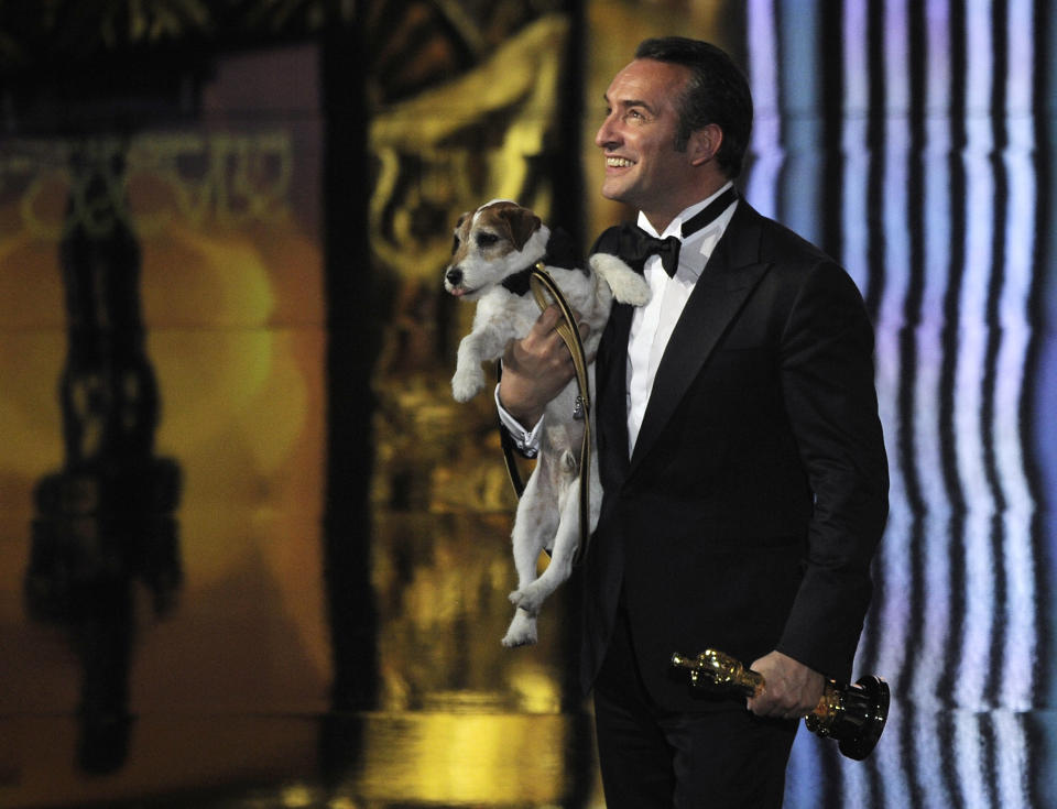 Jean Dujardin holds Uggie after accepting the Oscar for best picture for “The Artist” during the 84th Academy Awards on Monday, Feb. 27, 2012. (AP Photo/Mark J. Terrill)