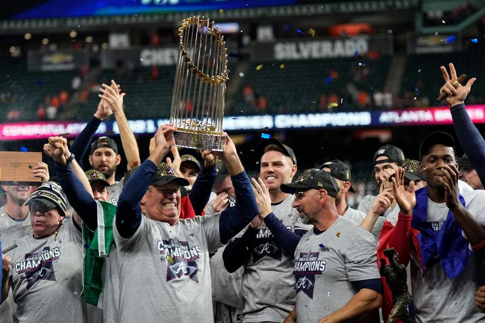 Atlanta Braves manager Brian Snitker holds up the trophy = after winning baseball's World Series in Game 6 against the Houston Astros Tuesday, Nov. 2, 2021, in Houston. The Braves won 7-0. (AP Photo/David J. Phillip)