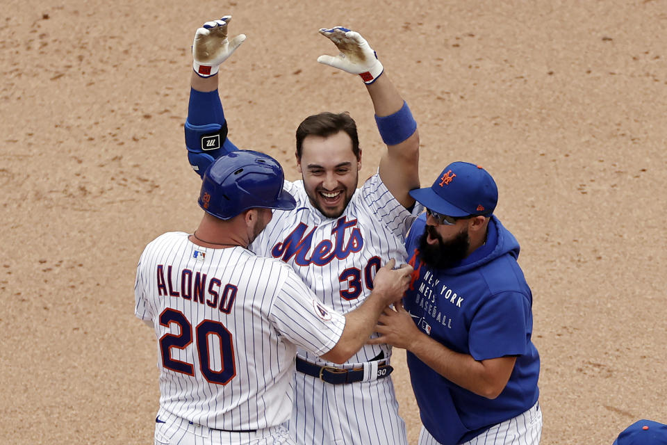 New York Mets' Michael Conforto celebrates his walk-off single with Pete Alonso and Luis Guillorme against the Miami Marlins during the ninth inning of the first game of a baseball doubleheader that started April 11 and was suspended because of rain, Tuesday, Aug. 31, 2021, in New York. The Mets won 6-5. (AP Photo/Adam Hunger)