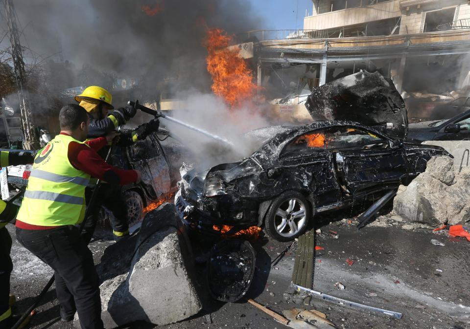 Lebanese firefighters extinguish a burning car at the site of an explosion near the Kuwaiti Embassy and Iran's cultural center, in the suburb of Beir Hassan, Beirut, Lebanon, Wednesday, Feb. 19, 2014. (AP Photo/Hussein Malla)