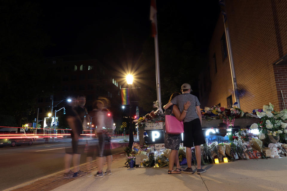 <p>Fredericton residents pay their respects at a makeshift shrine created in front of police headquarters after four people, including two police officers, were killed in a shooting in Fredericton on Aug. 10, 2018. (Photo from Reuters/Dan Culberson) </p>
