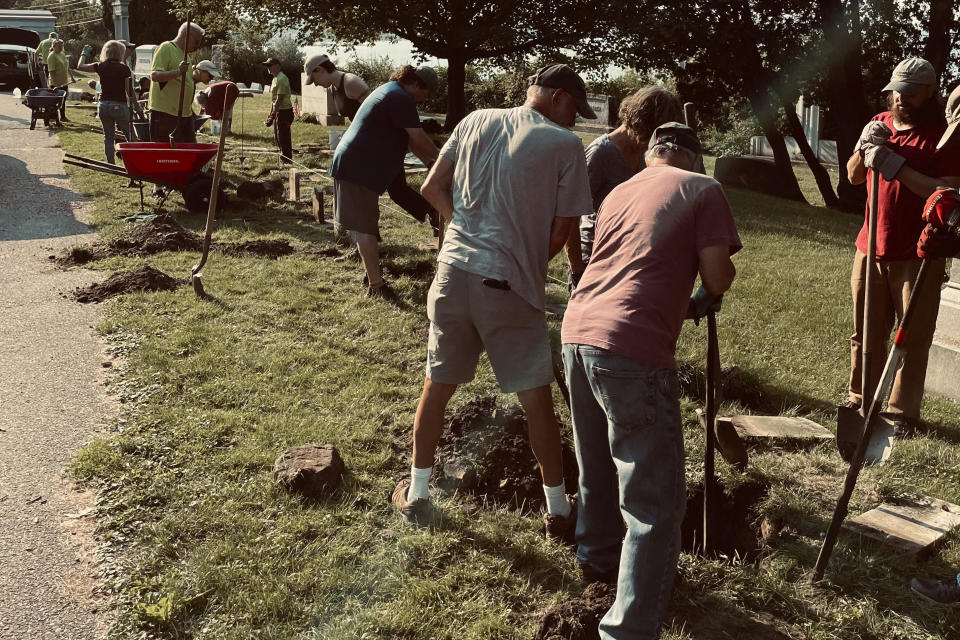 In this image provided by the Vermont Old Cemetery Association, volunteers from Vermont Old Cemetery Association and the Howard Center work to restore about 50 gravestones of children, on Saturday, Sept. 10, 2022, at Lakeview Cemetery in Burlington, Vt. The children lived and died in the late 1800s and early 1900s at the Home for Destitute Children, in Burlington, a former orphanage and boarding house that served children from around Vermont. (Tom Giffin/Vermont Old Cemetery Association via AP)