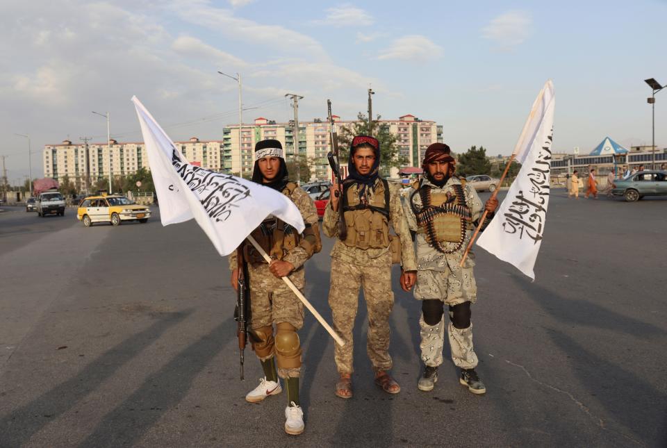 Militants hold Taliban flags in Kabul, Afghanistan, on Aug. 30. Many Afghans are anxious about the Taliban rule and are figuring out ways to get out of Afghanistan.