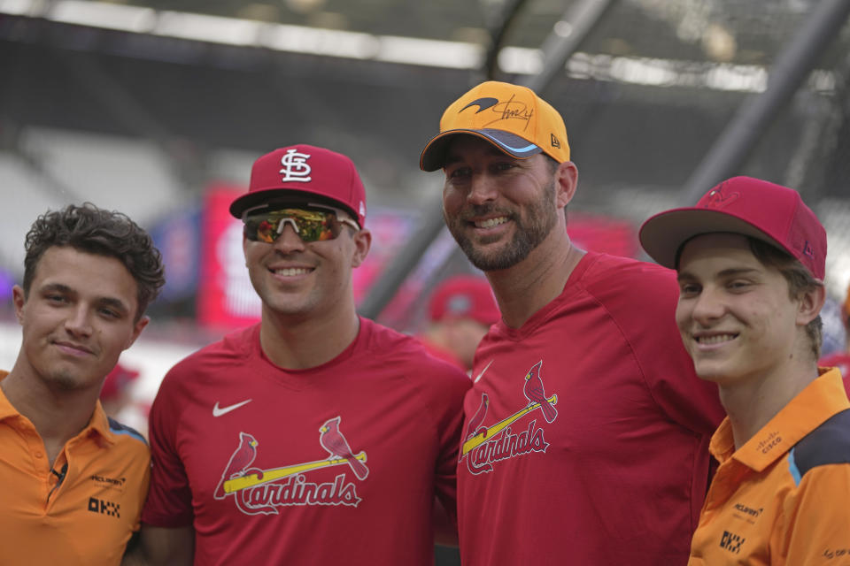 St. Louis Cardinals' Adam Wainwright, second right, poses with Formula One driver Lando Norris, left, during a training session ahead of the baseball match against Chicago Cubs at the MLB World Tour London Series, in London Stadium. (AP Photo/Kin Cheung)