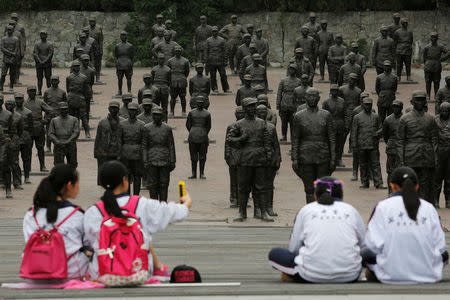 Students sit at the Chinese Heroes Statues Plaza, which displays war heroes from the War of Resistance against Japan, in Jianchuan Museum Cluster in Anren, Sichuan Province, China, May 13, 2016. REUTERS/Kim Kyung-Hoon